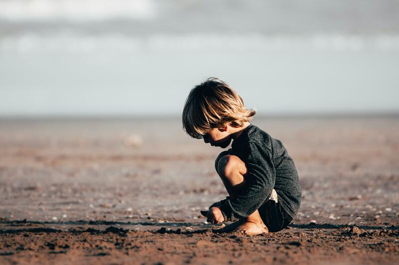 A child on a beach at dusk